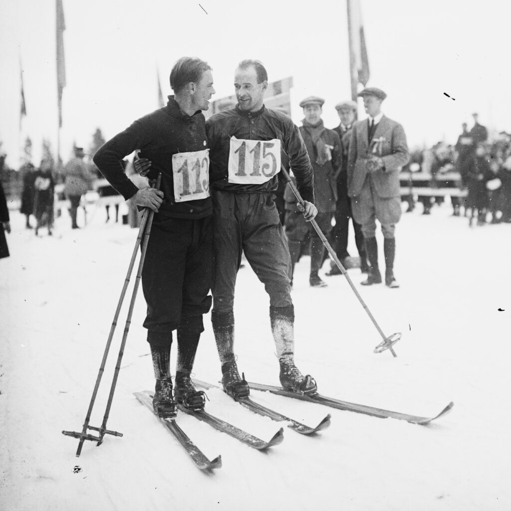 Bilde av langrennsløperne Thorleif Haug og Johan Grøttumsbråten som snakker sammen.